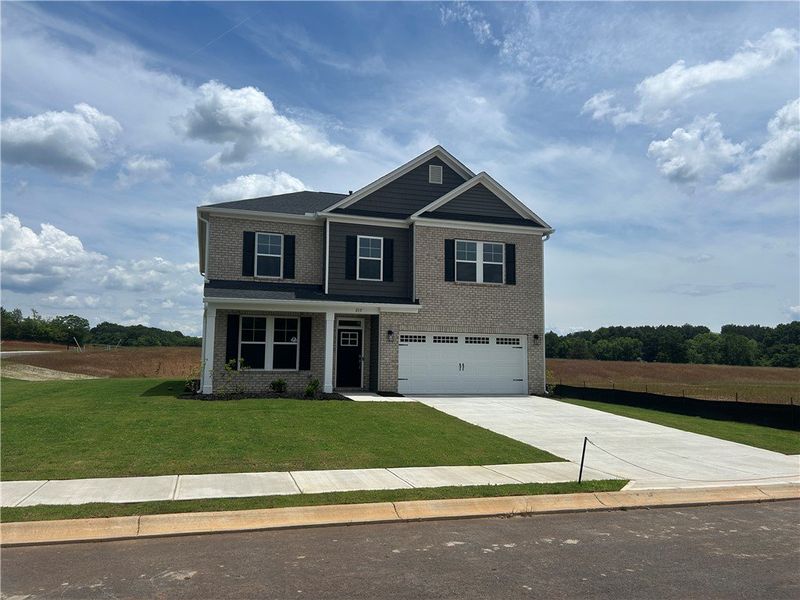 A well-maintained lawn and extended driveway enhan
