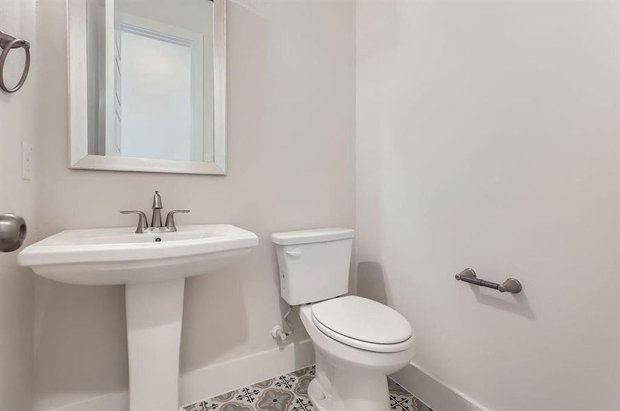 Bathroom featuring sink, tile patterned floors, and toilet