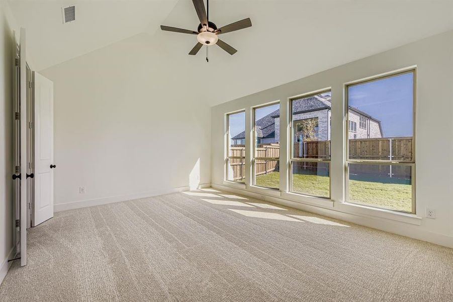 Spare room with light colored carpet, high vaulted ceiling, and ceiling fan