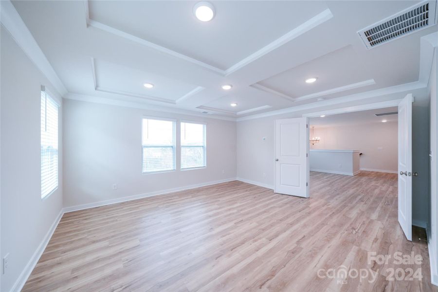 Primary Bedroom features 4-Square Micro Tray ceiling and EVP Flooring