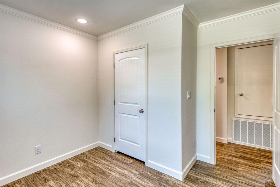 Recessed lighting illuminates wood-look flooring and clean crown molding details. Recessed lighting illuminates wood-look flooring and clean crown molding details.