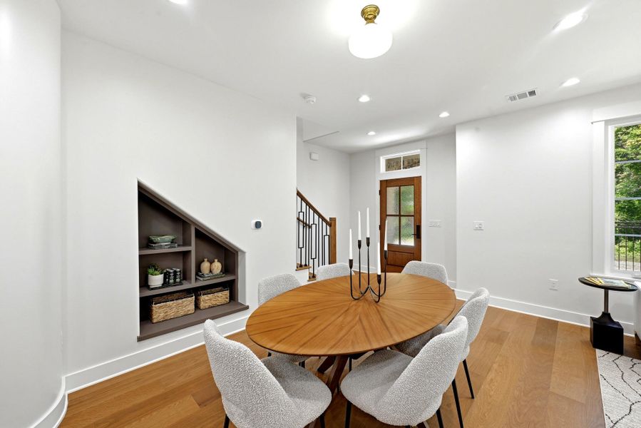 A formal dining area with custom built-in shelving and richly toned wood flooring. A formal dining area with custom built-in shelving and richly toned wood flooring.