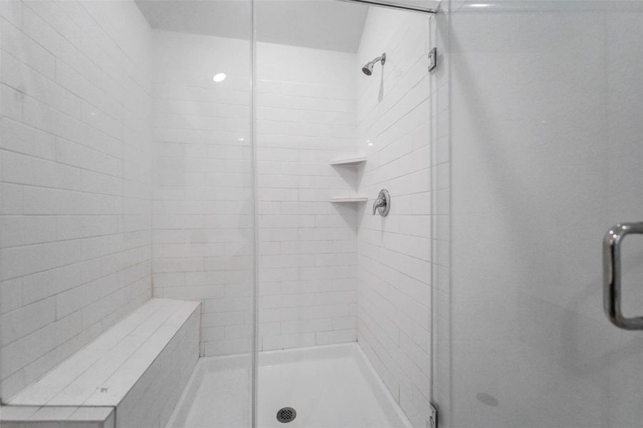 Upgraded walk-in shower with subway tile, built-in shelves, and a full bench—perfect for relaxing after a long day. Upgraded walk-in shower with subway tile, built-in shelves, and a full bench—perfect for relaxing after a long day.