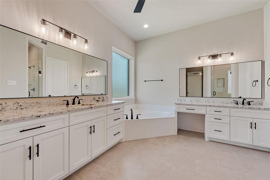 Full bath featuring a stall shower, a bath, two vanities, ceiling fan, and tile patterned floors