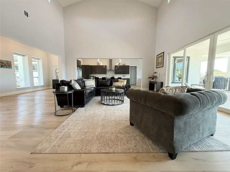Living area with light wood finished floors and a high ceiling