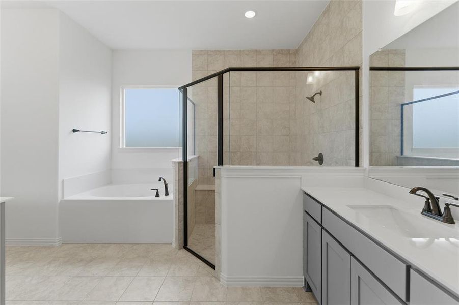 The bathroom features a built-in bathtub, a walk-in shower with tiled walls and a bench, and a vanity with a countertop and undermount sink
