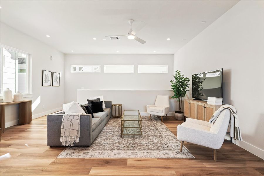 Clerestory windows add a layer of natural light above the living room, creating a brighter space without direct sightlines from neighboring homes.