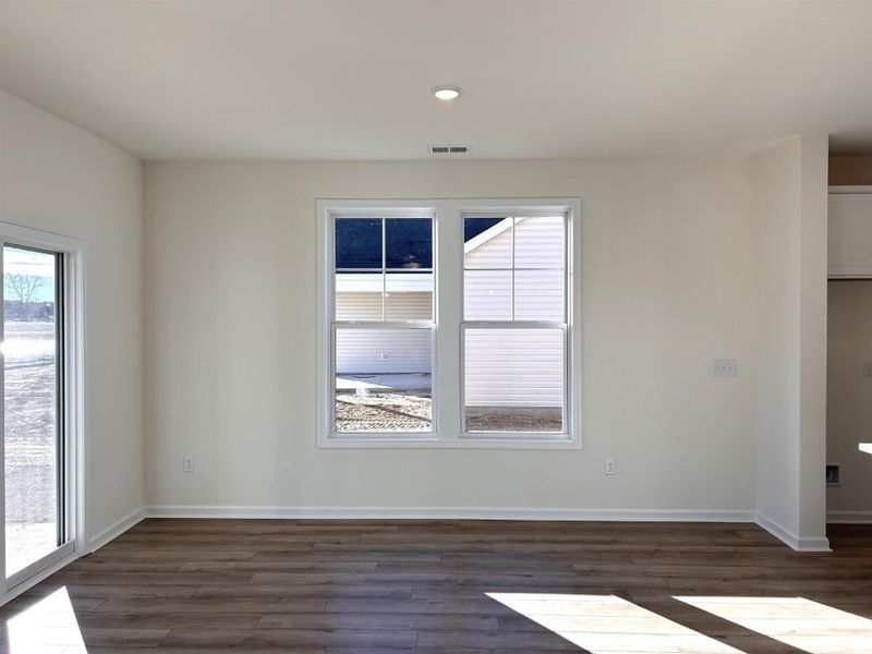Empty room featuring dark wood-type flooring and recessed lighting