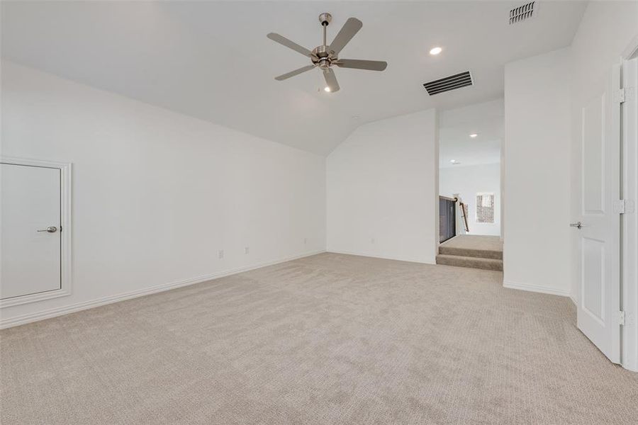 Bonus room with ceiling fan, light colored carpet, and vaulted ceiling