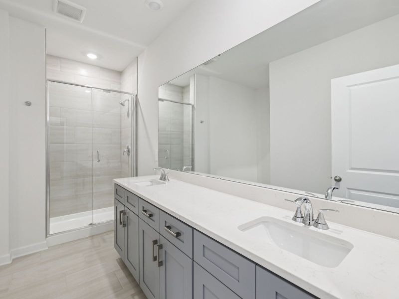 The primary bathroom boasts a large dual-sink vanity and modern walk-in shower. The primary bathroom boasts a large dual-sink vanity and modern walk-in shower.