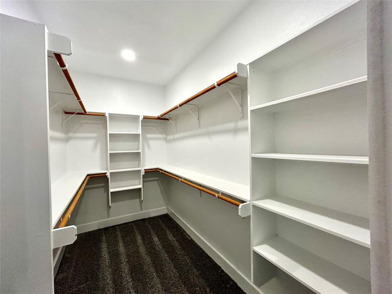 Primary walk-in closet adjacent to the primary bathroom