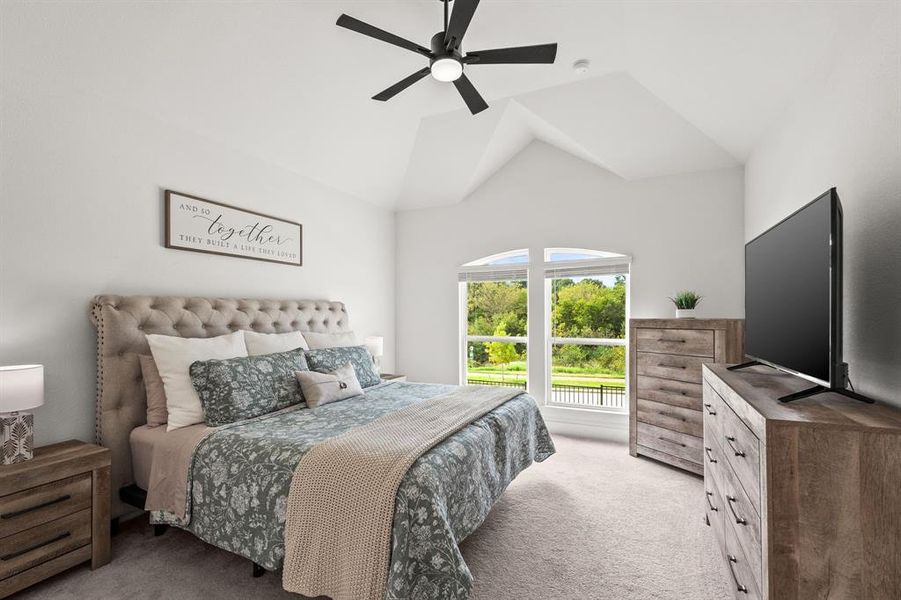 Carpeted bedroom featuring a ceiling fan and vaulted ceiling Carpeted bedroom featuring a ceiling fan and vaulted ceiling