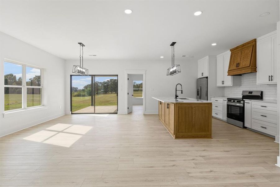 Kitchen featuring white cabinetry, pendant lighting, backsplash, stainless steel appliances, and recessed lighting