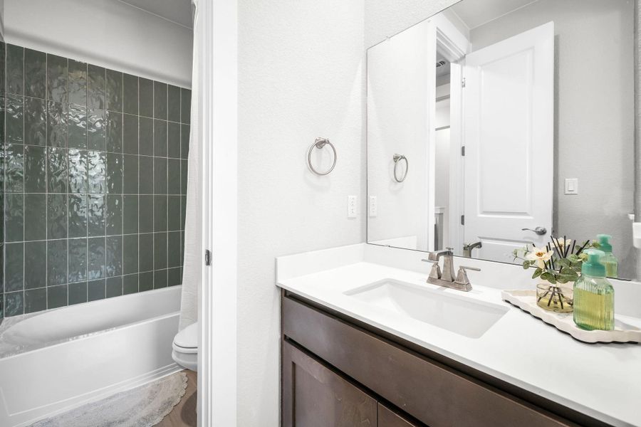 A well-appointed bath features a sleek vanity and subway tile in the shower.