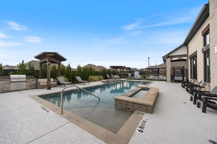 Community swimming pool featuring a patio, area for grilling, and a pool with connected hot tub