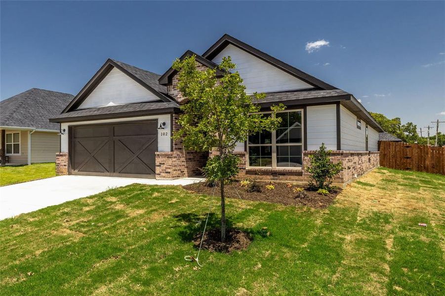 View of front of house with a garage and a front lawn