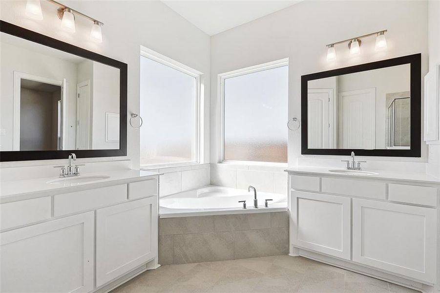 Bathroom with a garden tub, two vanities, light tile patterned flooring, and a shower stall