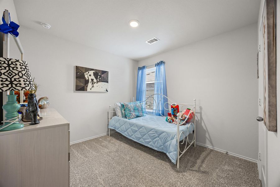 Bedroom featuring light carpet and baseboards