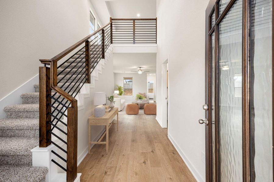 A bright and welcoming entryway featuring clean lines, modern railing details, and natural light that sets the tone for the home’s contemporary style. A bright and welcoming entryway featuring clean lines, modern railing details, and natural light that sets the tone for the home’s contemporary style.
