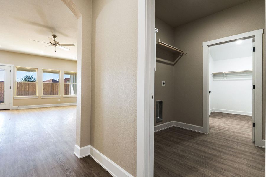 Laundry area featuring dark wood-style floors, ceiling fan, and electric dryer hookup