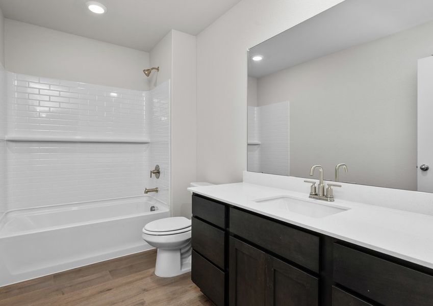 The secondary bathroom has a sprawling vanity and a shower-tub combo. The secondary bathroom has a sprawling vanity and a shower-tub combo.