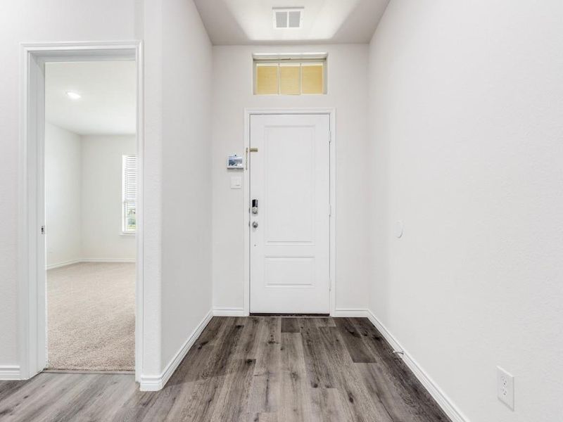 Foyer entrance featuring baseboards and wood finished floors