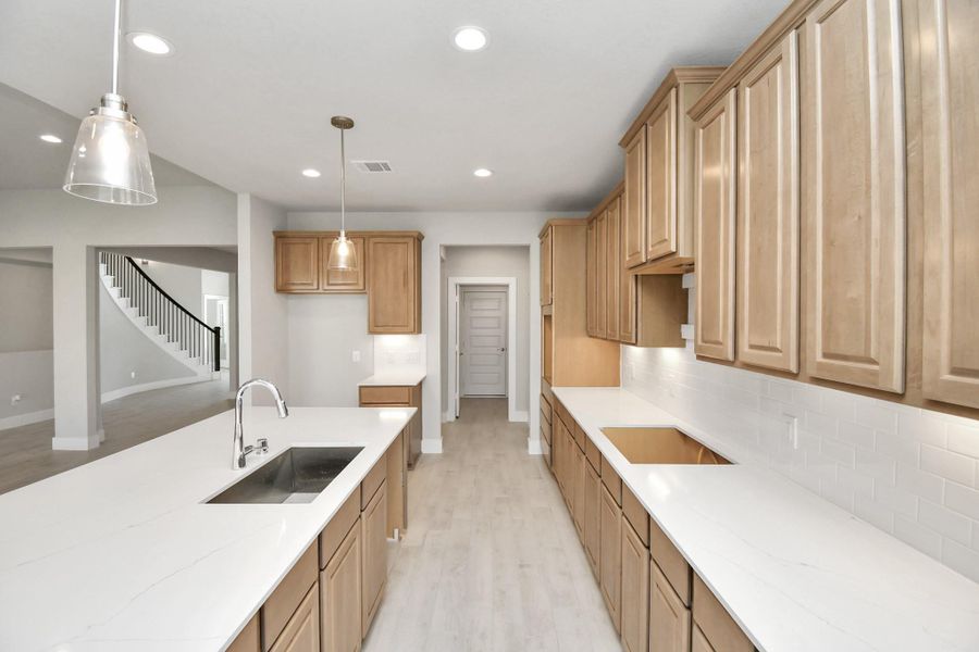 This kitchen is by far any chef’s dream! This spacious kitchen features high ceilings, light stained wood cabinets, granite countertop, SS appliances, modern tile backsplash, recessed lighting, extended counter space, granite kitchen island with double sink, and space for breakfast bar, and a walk-in pantry all overlooking your huge family room. Sample photo of completed home with similar floor plan. Actual colors and selections may vary. This kitchen is by far any chef’s dream! This spacious kitchen features high ceilings, light stained wood cabinets, granite countertop, SS appliances, modern tile backsplash, recessed lighting, extended counter space, granite kitchen island with double sink, and space for breakfast bar, and a walk-in pantry all overlooking your huge family room. Sample photo of completed home with similar floor plan. Actual colors and selections may vary.