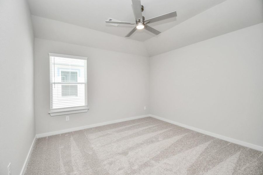 Secondary bedroom features plush carpeting, large windows that let in plenty of natural light, bright paint, and spacious closets. Sample photo of completed home with similar floor plan. Actual colors and selections may vary.