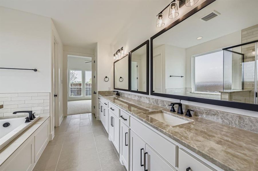 Bathroom featuring double vanity, a garden tub, a stall shower, light tile patterned flooring, and a ceiling fan Bathroom featuring double vanity, a garden tub, a stall shower, light tile patterned flooring, and a ceiling fan