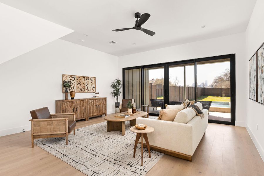 Living area with a ceiling fan and light wood-type flooring
