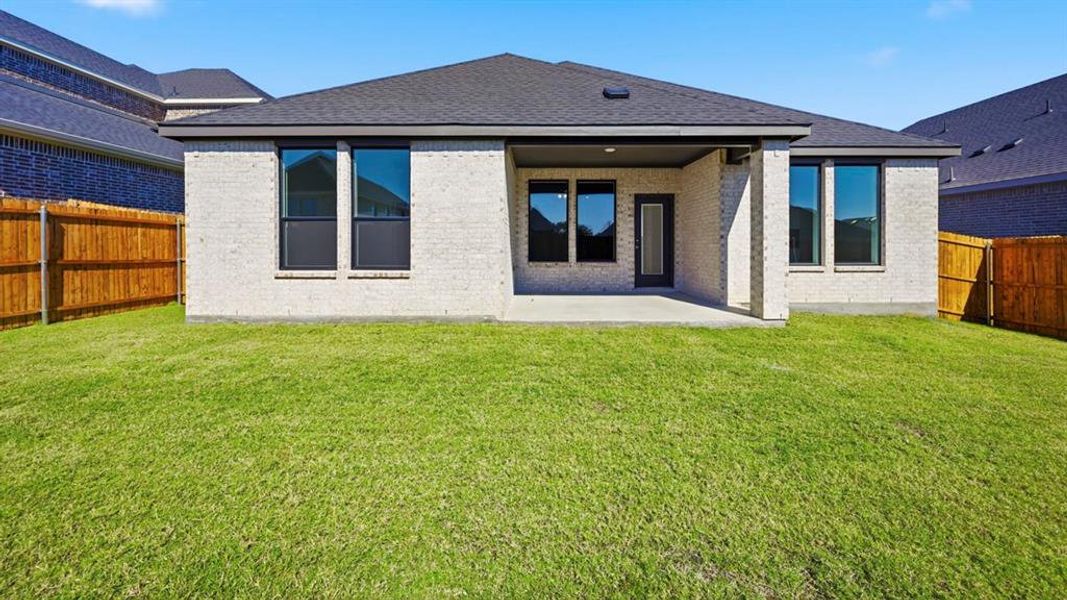 Rear view of property with a fenced backyard, a patio area, brick siding, and a shingled roof Rear view of property with a fenced backyard, a patio area, brick siding, and a shingled roof