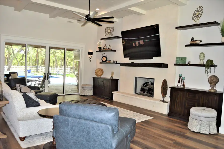 Living area featuring beamed ceiling, luxury vinyl floors and fireplace Living area featuring beamed ceiling, luxury vinyl floors and fireplace