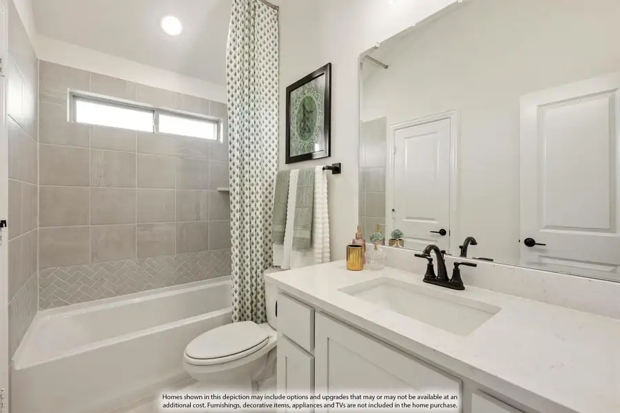 Bathroom with white vanity, quartz countertop, tiled tub-shower combo, and large mirror
