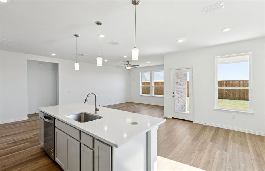 Large island overlooking gathering room and dining areas