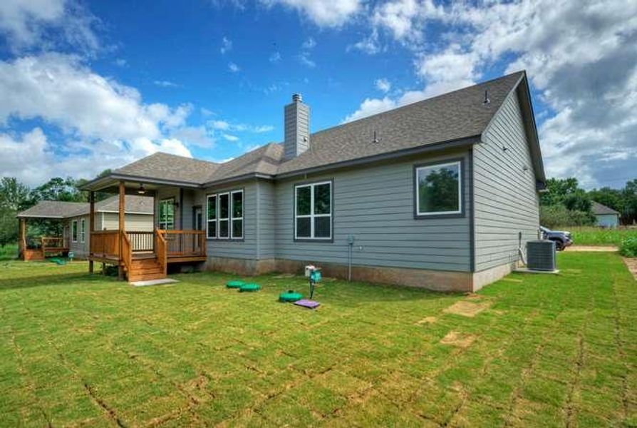 A newly sodded lawn and covered wooden deck define the backyard retreat of this inviting residence.