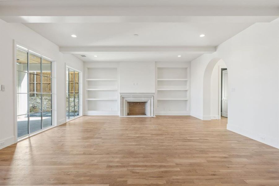 Living room featuring light hardwood flooring and built in shelves