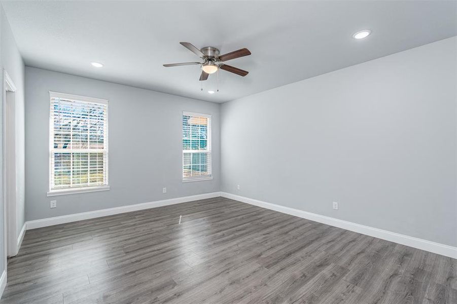 Empty room with a ceiling fan, baseboards, and wood finished floors