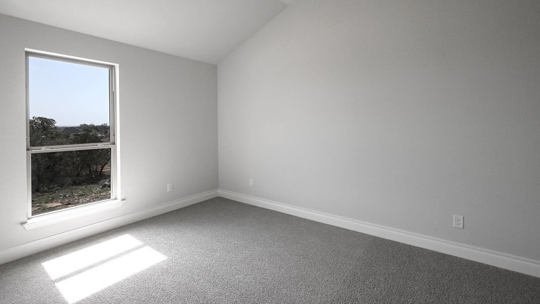 Unfurnished room featuring carpet, lofted ceiling, and baseboards Unfurnished room featuring carpet, lofted ceiling, and baseboards