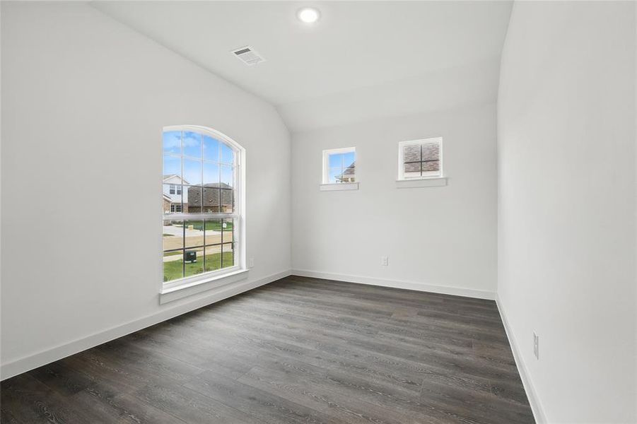 Empty room featuring lofted ceiling, dark wood-style floors, and recessed lighting Empty room featuring lofted ceiling, dark wood-style floors, and recessed lighting