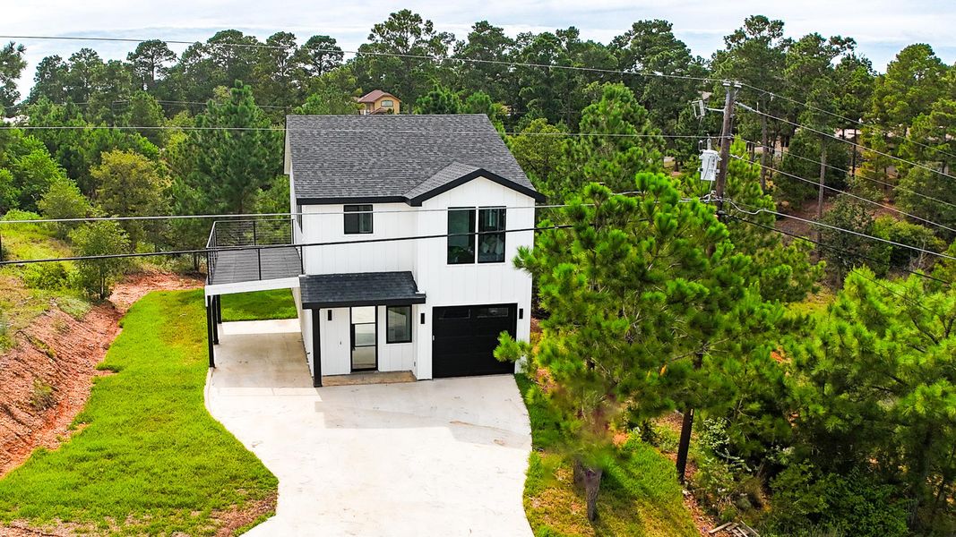 View of front of home featuring roof with shingles, concrete driveway, a garage, a carport, and a balcony View of front of home featuring roof with shingles, concrete driveway, a garage, a carport, and a balcony