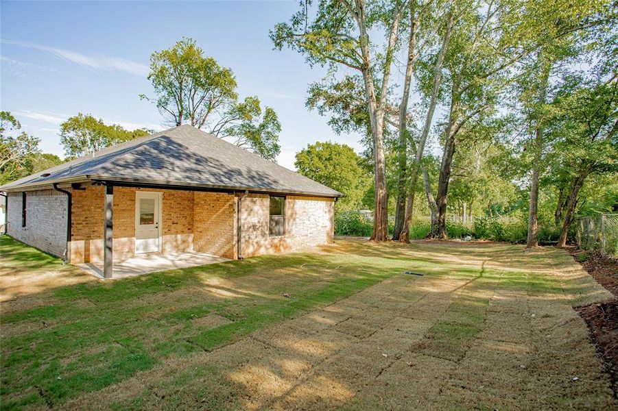 Back of property with brick siding, a patio, and roof with shingles Back of property with brick siding, a patio, and roof with shingles