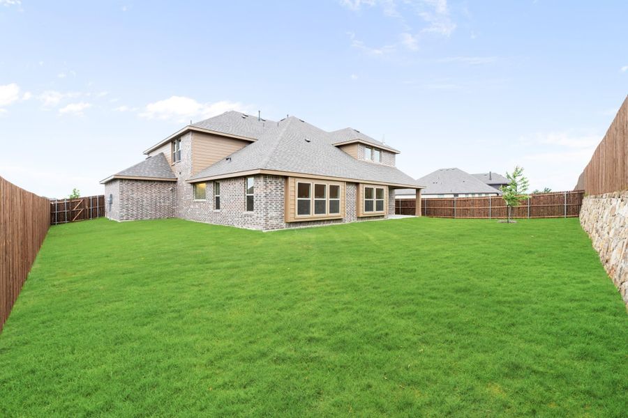 Brick two-story home with large fenced backyard and green lawn Brick two-story home with large fenced backyard and green lawn
