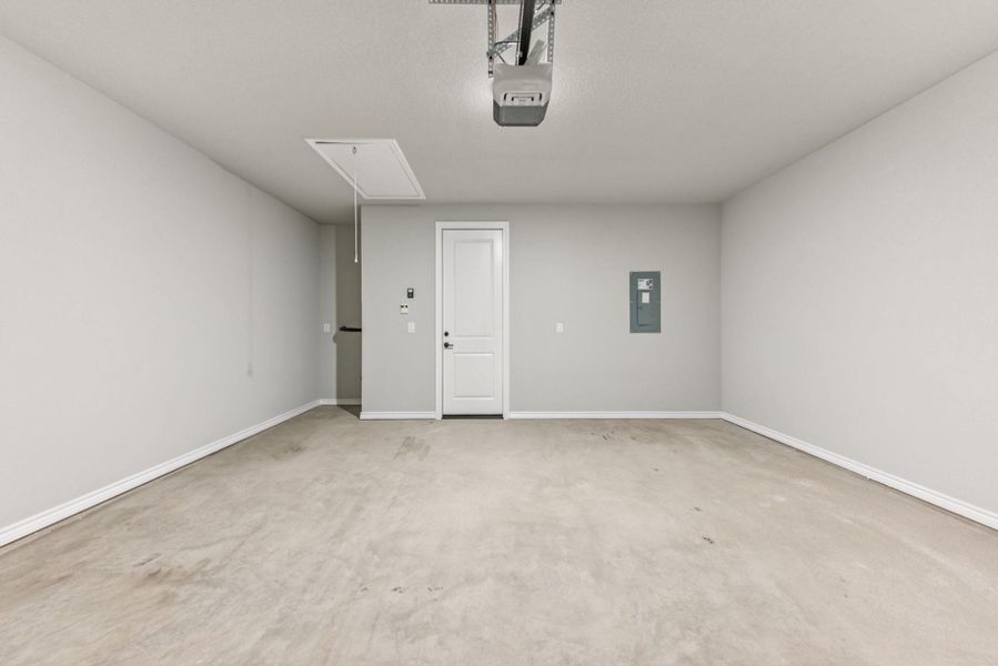 Garage featuring electric panel and a garage door opener Garage featuring electric panel and a garage door opener