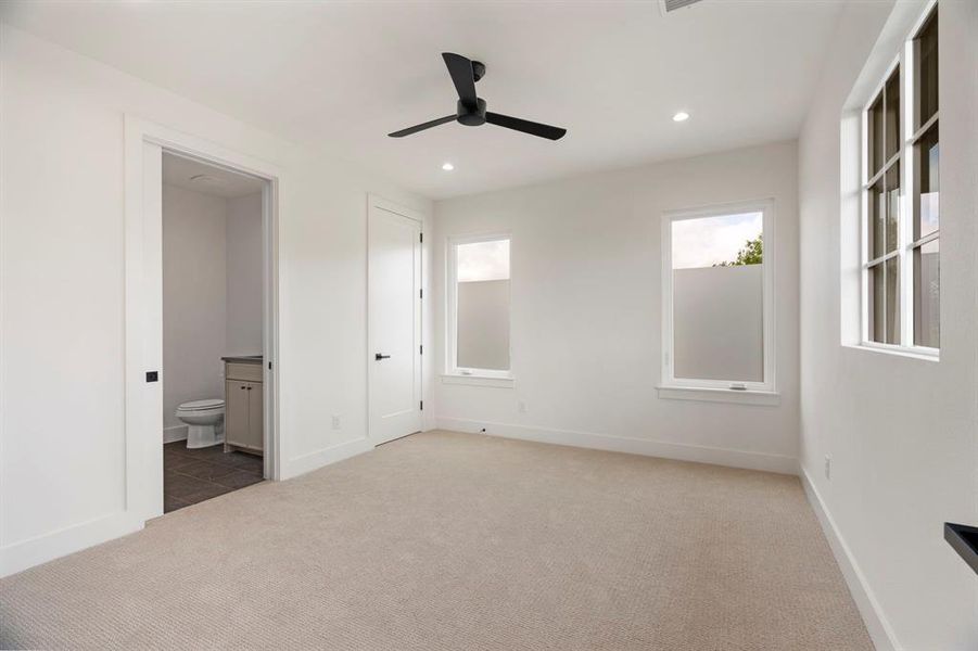 Unfurnished bedroom featuring carpet floors, recessed lighting, ceiling fan, and ensuite bath Unfurnished bedroom featuring carpet floors, recessed lighting, ceiling fan, and ensuite bath