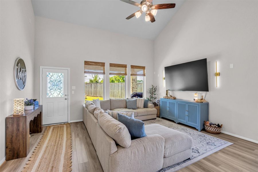 It features a bright, open feel with three large glass windows overlooking the backyard. A convenient door provides direct access to the outdoor space, creating an easy connection between indoor and outdoor living.