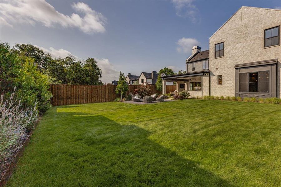Expansive green lawn with a solid wood privacy fence Expansive green lawn with a solid wood privacy fence