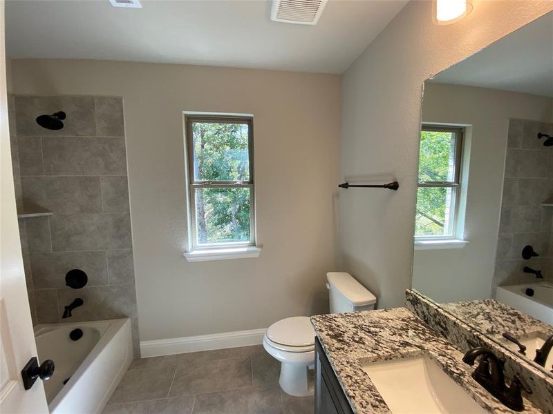 Full bathroom 2 with granite vanity, tub/shower combo, and 12x24 tile on floor & shower walls