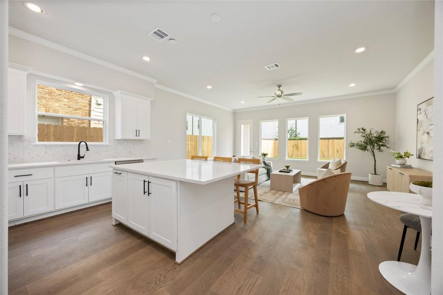 Comfort meets chic: Dive into this spacious kitchen's inviting island that’s perfect for brunch, buffets, and big laughs with loved ones.