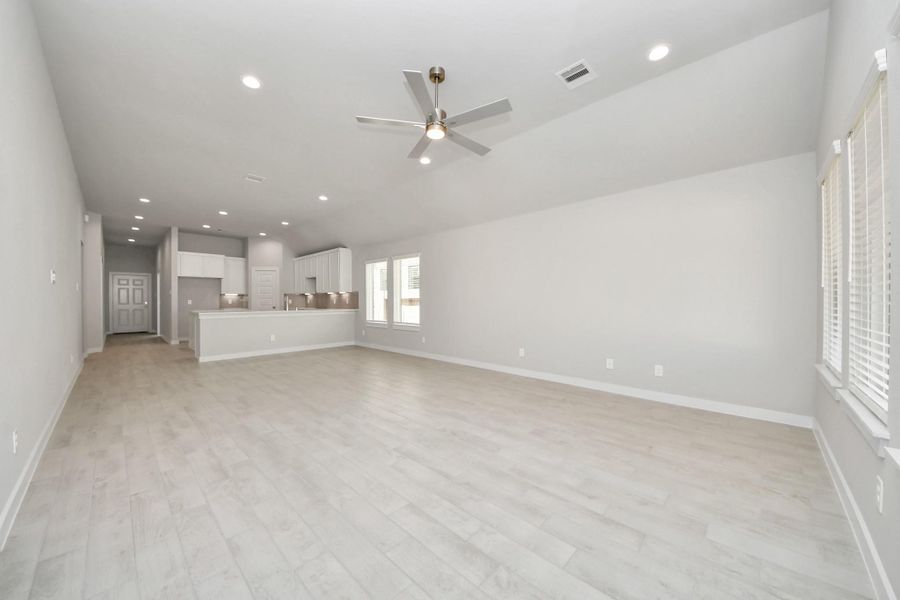 Gather the family and guests together in your lovely living room! Featuring soaring high ceilings, recessed lighting, ceiling fan, custom paint, gorgeous floors, and large windows that provide plenty of natural lighting throughout the day. Sample photo of completed home with similar floor plan. Actual colors and selections may vary.
