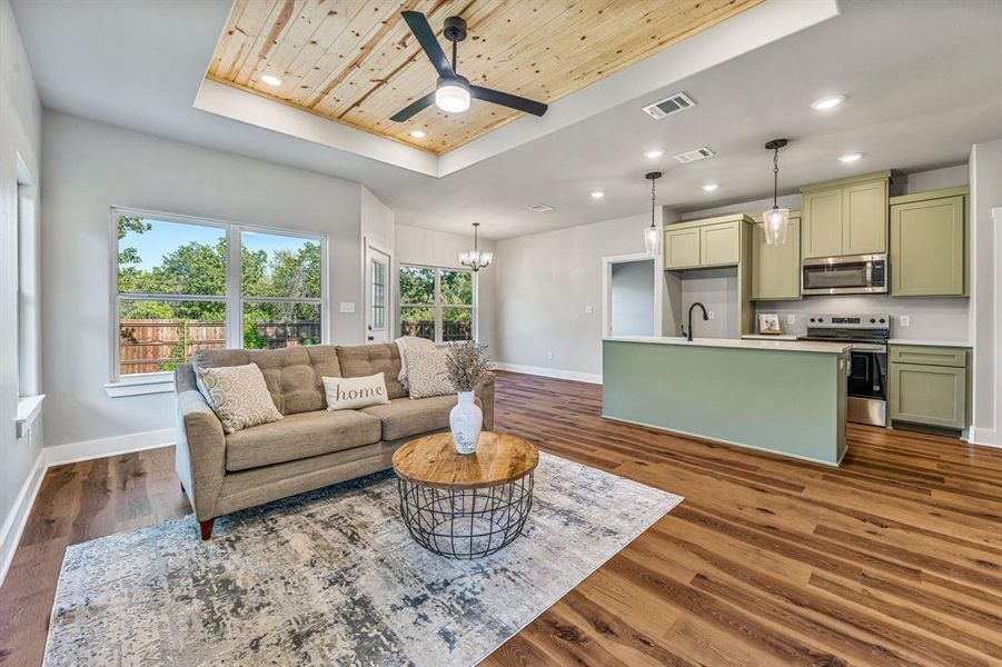 Living area with a raised ceiling, wood ceiling, recessed lighting, a chandelier, and dark wood-style floors Living area with a raised ceiling, wood ceiling, recessed lighting, a chandelier, and dark wood-style floors